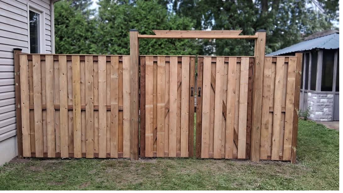 Custom shadowbox cedar fence with pergola-top gate by Omni Fence
